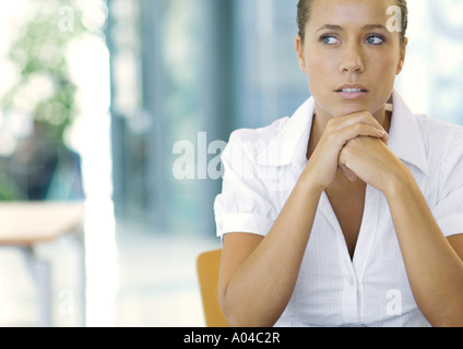 Imprenditrice con le mani incrociate sotto il mento, ritratto Foto Stock