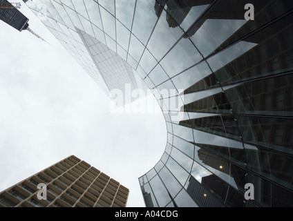 Grattacielo con la riflessione di edifici sulla facciata, angolo basso, vista astratta Foto Stock