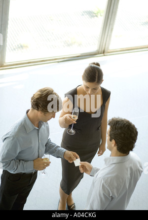 I dirigenti lo scambio di business card durante il cocktail party Foto Stock