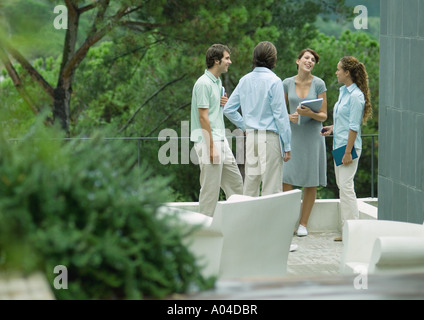 Casualmente vestito giovani dirigenti in piedi all'aperto, parlando Foto Stock