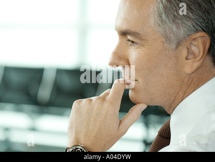 Uomo seduto nella sala di attesa di un aeroporto, close-up di faccia Foto Stock