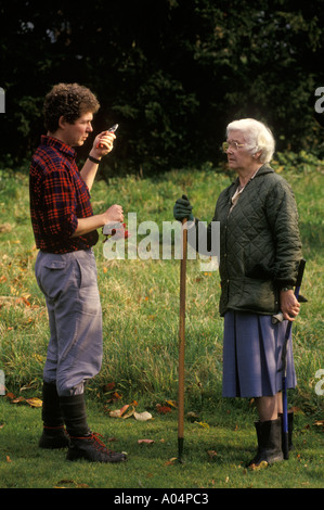 La vecchiaia titolare di pensione o di rendita il giardinaggio con maschio giovane giardiniere Inghilterra HOMER SYKES Foto Stock