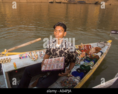 VARANASI Uttar Pradesh India Novembre Hawker cercando di vendere il suo negozio di souvenir per i visitatori in viaggio sul fiume Gange Foto Stock