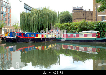 Fila di chiatte narrowboat allineati fianco a fianco e riflessa nel canale, Regent's Canal, Islington, London, Regno Unito Foto Stock