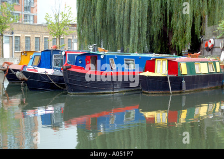 Fila di chiatte narrowboat allineati fianco a fianco e riflessa nel canale, Regent's Canal, Islington, London, Regno Unito Foto Stock