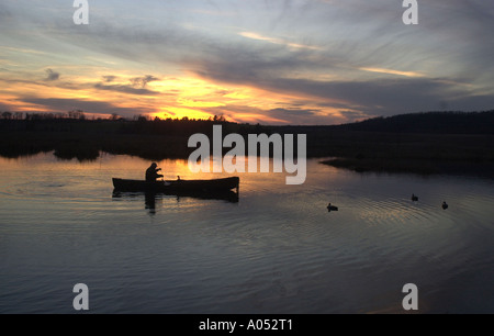 Un cacciatore di anatre riprende il suo decoy al tramonto in Bristol, Vermont dopo una giornata di caccia. Foto Stock