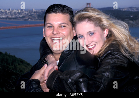 Coppia felice in amore abbracciando al Golden Gate Bridge di San Francisco in California Foto Stock