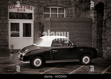 Tonalità seppia foto di un nero Nissan Figaro con un tetto bianco. Foto Stock