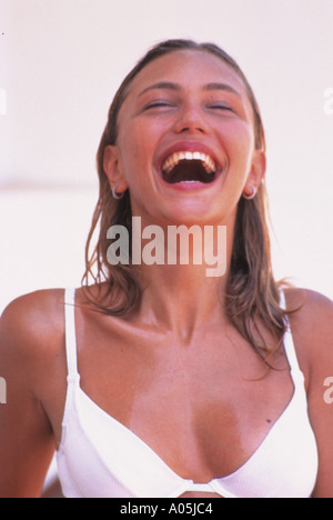 Ritratto di un attraente ragazza ridere e indossando un bikini bianco top Foto Stock