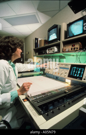 Sonno femmina terapista controlla attività EEG in un laboratorio del sonno impostazione Foto Stock