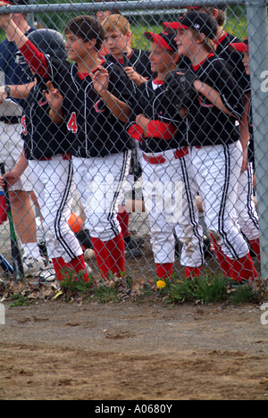 Ragazzi su di una squadra di baseball folla la recinzione per guardare passo importante. Foto Stock