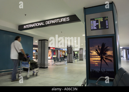 Viaggiatore a piedi in aeroporto alla zona di partenza (Palm tree poster è mio) Foto Stock
