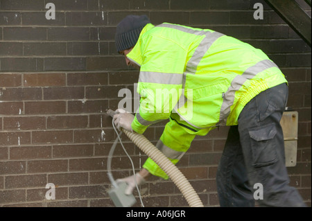 Mettere la cavità parete di isolamento in una casa a Ambleside, Cumbria, Regno Unito Foto Stock