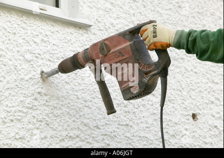 Mettere la cavità parete di isolamento in una casa a Ambleside, Cumbria, Regno Unito Foto Stock