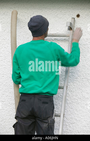 Mettere la cavità parete di isolamento in una casa a Ambleside, Cumbria, Regno Unito Foto Stock