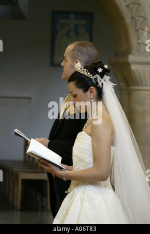 Sposa e lo Sposo cantando inni durante il regno unito la cerimonia nuziale Foto Stock