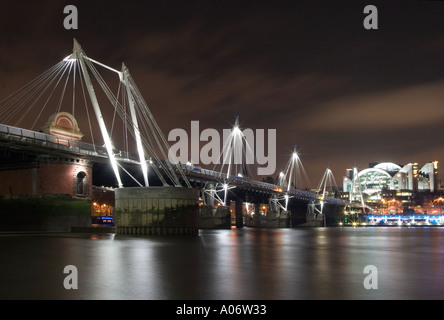 Hungerford Bridge e la stazione di Charing Cross di notte dal Tamigi foreshore. Londra, Inghilterra Foto Stock