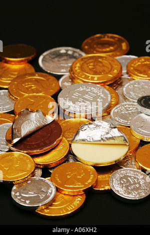 Argento e Oro ricoperto di lamina latte e cioccolato bianco novità monete spiccioli in un mucchio di bambini dolci caramelle chicche di pasticceria Foto Stock
