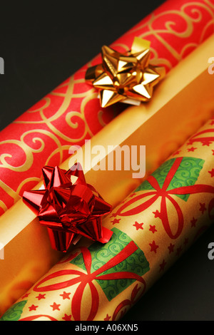 Rotoli di festosa Natale regalo di Natale regalo carta di avvolgimento con rosso e oro fiocchi di nastro spazio per testo greeting card immagine Foto Stock