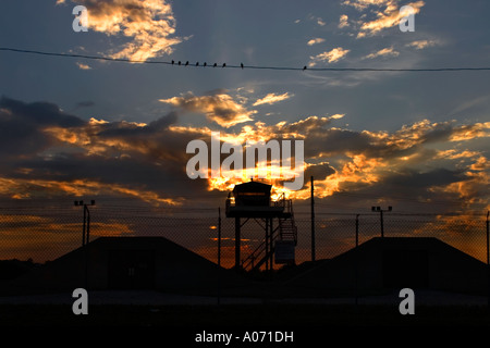 Drammatico il cielo al tramonto con arma bunker edifici e uccelli Foto Stock