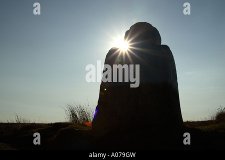 Fat Betty noto anche come croce bianca un antico monumento di pietra sul ventoso Danby alta Moor silhouette retroilluminato Foto Stock