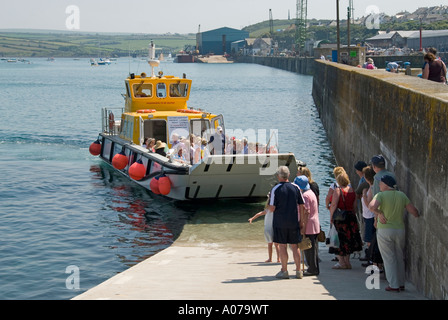 Nero traghetto Tor restituendo i passeggeri in arrivo al porto di Padstow parete da roccia dopo aver attraversato il fiume di marea Camel passeggeri in attesa sulla rampa di imbarco Foto Stock