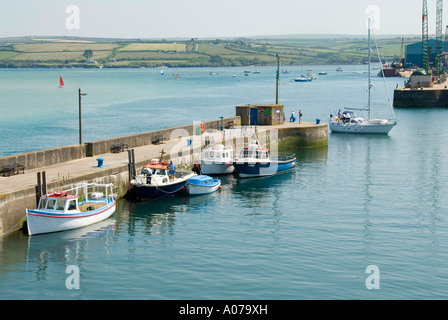 Sailing yacht entra Cornish Padstow porto dal fiume estuario del cammello su North Cornwall coast a unirsi a piccole imbarcazioni ormeggiate lungo la parete del porto Foto Stock