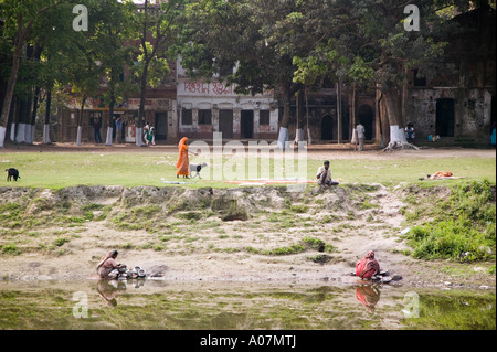 Donne lavando pentole sul greto del fiume in Sonargoan Bangladesh Foto Stock