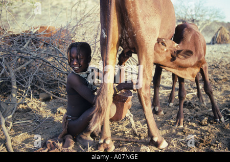 Ragazza Himba mucca mungitura Damaraland Namibia Foto Stock