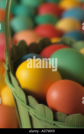 Uova colorate in verde cesto in legno vicino fino pasqua Foto Stock