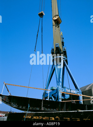 Gru di grandi dimensioni che posiziona una sezione della chiglia di una nave su uno scivolo del cantiere, Wallsend, Tyneside, Tyne & Wear, Inghilterra, UK. Negli anni '90 Foto Stock