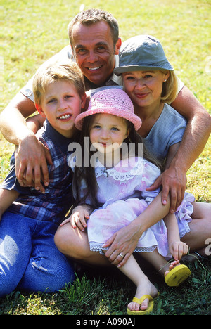 Ritratto di una famiglia seduta su un prato Foto Stock
