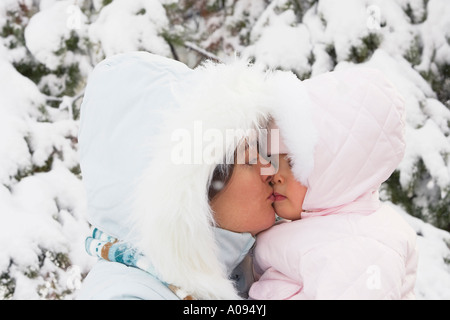 Madre baciare bimba in doposci Foto Stock