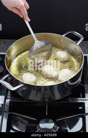 Panna acida ciambelle la cottura in olio Foto Stock