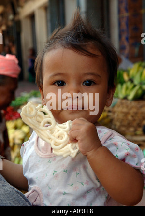 Baby girl in armi, Bali Indonesia Foto Stock