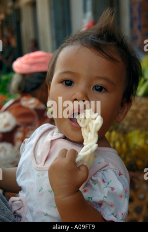 Baby girl in armi, Bali Indonesia Foto Stock