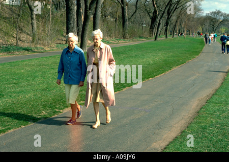 Donna anziana età 75 passeggiando attorno al lago Calhoun. Minneapolis Minnesota USA Foto Stock