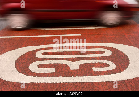 Una macchina passa oltre trenta miglia per ora gli avvisi di velocità dipinta sul manto stradale Regno Unito Foto Stock