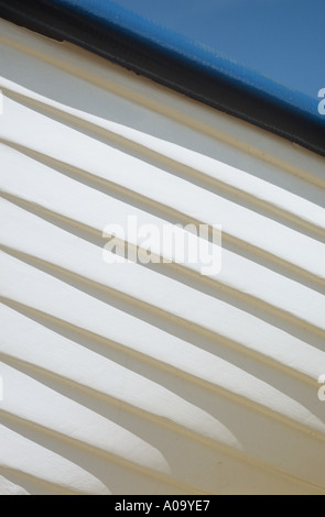 Dettaglio visto dal di sotto del bianco nello scafo di una imbarcazione in legno con il blu del cielo visibile sopra Foto Stock