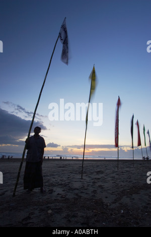 Silhouette di un uomo in piedi accanto alla bandiera , Spiaggia di Legian Beach Foto Stock