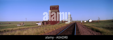 Elevatori della granella al fianco di ferrovia via su prairie Devon Montana Foto Stock