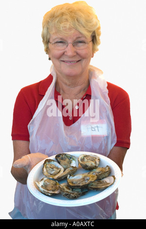Ritratto senior donna caucasica tenendo la piastra di ostriche Foto Stock