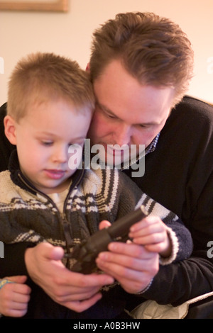 Papà e figlio guardando alla pistola giocattolo età 36 e 5. Plymouth Minnesota MN USA Foto Stock