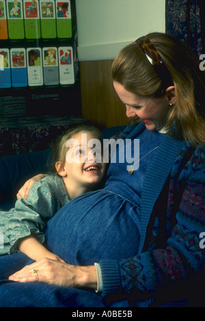 Donna incinta con la figlia a casa abbiamo anche home la scuola foto disponibili con questa famiglia anche vedere JHP1313 Foto Stock