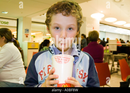 Bambino bere McDonald's soft drink, England Regno Unito Foto Stock