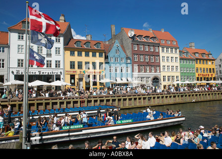 Gita turistica di barche sul canale Nyhavn e quayside terrazze dei bar, Copenhagen, Danimarca Foto Stock