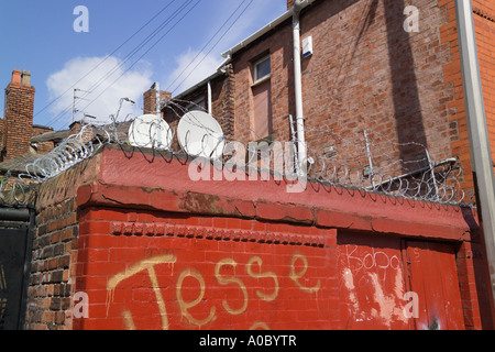 Filo spinato sulla parte superiore delle pareti in mattoni Anfield Liverpool Merseyside England Foto Stock