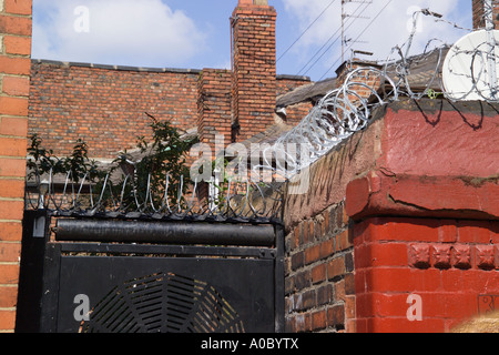 Filo spinato sulla parte superiore delle pareti in mattoni Anfield Liverpool Merseyside England Foto Stock