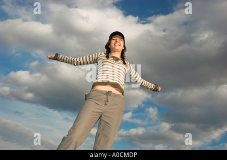 Giovane donna con trecce che indossa il cappuccio esterno permanente braccia tese Foto Stock