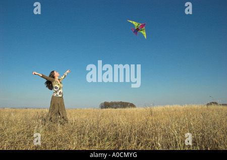 Giovane donna nel campo aquilone volante Foto Stock